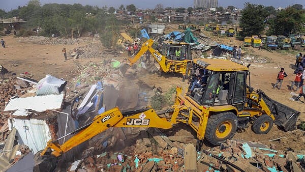 <div class="paragraphs"><p>Backhoe loaders being used by the Amdavad Municipal Corporation (AMC) during a demolition drive near Chandola lake, in Ahmedabad.</p></div>