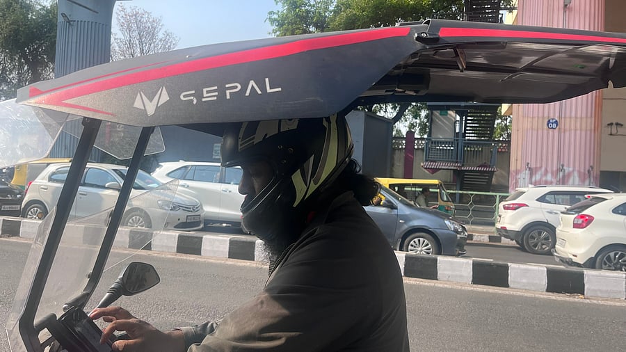 <div class="paragraphs"><p>Kavi Ravindra, an Uber bike rider, has a custom-installed bike shield that resembles a car roof. </p></div>
