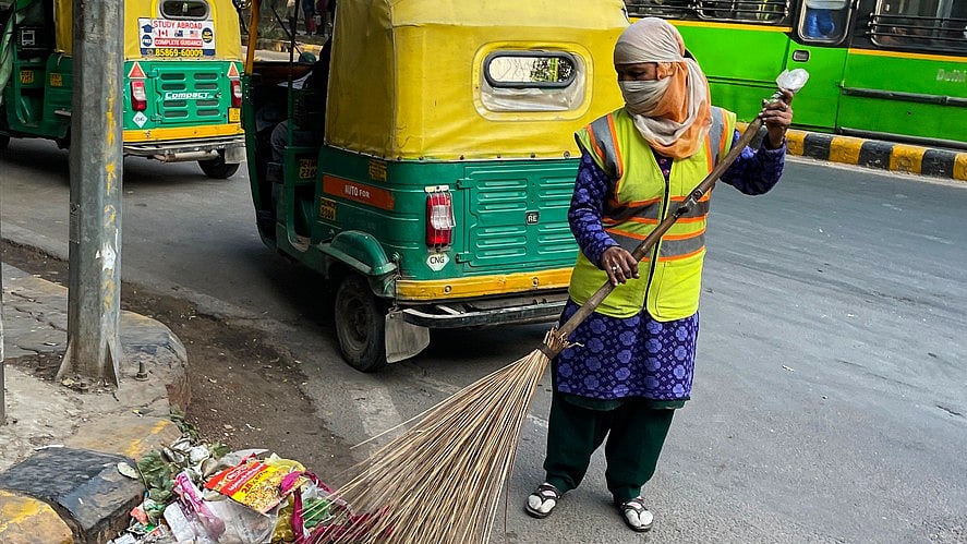 <div class="paragraphs"><p>A worker sweeps a road in Delhi. (File photo)</p></div>