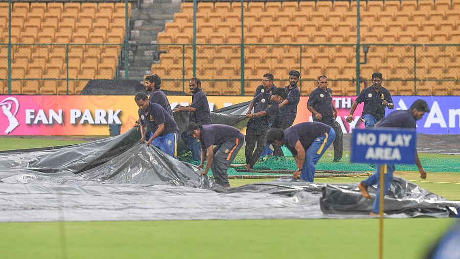 <div class="paragraphs"><p>Groundstaff scamper to cover the square as heavy shower disrupted RCB’s practice at M Chinnaswamy Stadium, ahead of their clash against CSK, on Friday. </p></div>