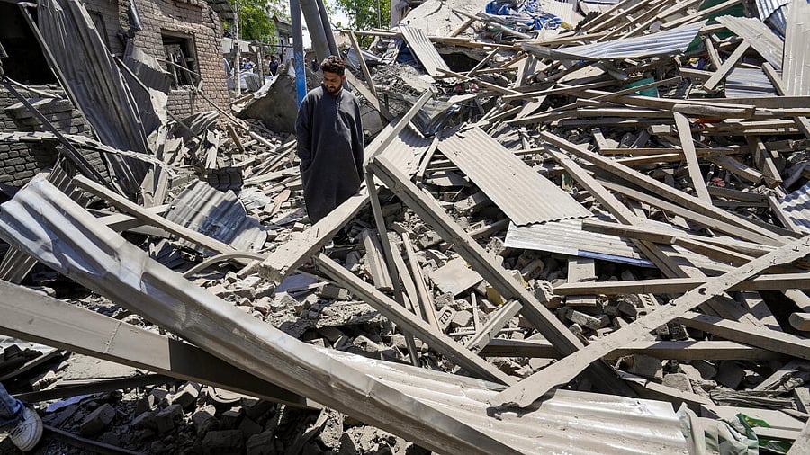 <div class="paragraphs"><p>A man stands amid the debris of the house of Ahsan Ul Haq Sheikh, a suspect in the Pahalgam terror attack, which was razed in a blast, in Murran area of Pulwama district, Saturday, April 26, 2025.</p></div>