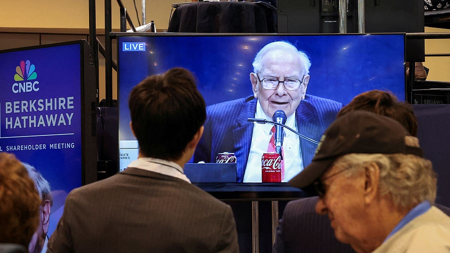 <div class="paragraphs"><p>People watch as Berkshire Hathaway chairman Warren Buffett is seen on a screen speaking at the Berkshire Hathaway Inc annual shareholders' meeting, in Omaha, Nebraska, US, May 3, 2025. </p></div>