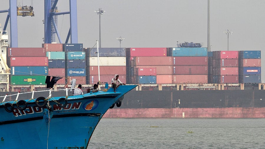 <div class="paragraphs"><p>FILE PHOTO: Fishermen sit in a trawler navigating past containers stalked on a ship at a port in Vallarpadam in the southern Indian city of Kochi December 11, 2013. </p></div>