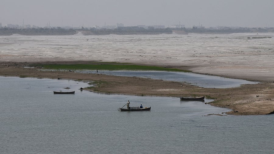 <div class="paragraphs"><p>A man navigates a boat in the water next to the dry riverbed of the Indus River in Hyderabad, Pakistan.</p></div>