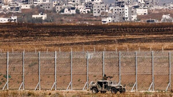 <div class="paragraphs"><p>An Israeli military vehicle patrols on the Israeli side of the Gaza border</p></div>