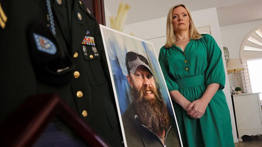 <div class="paragraphs"><p>Stacey Wales, 47, stands next to a photo of her brother, Chris Pelkey, who died in a road rage shooting in 2021, in Chandler, Arizona, US, May 8, 2025.</p></div>