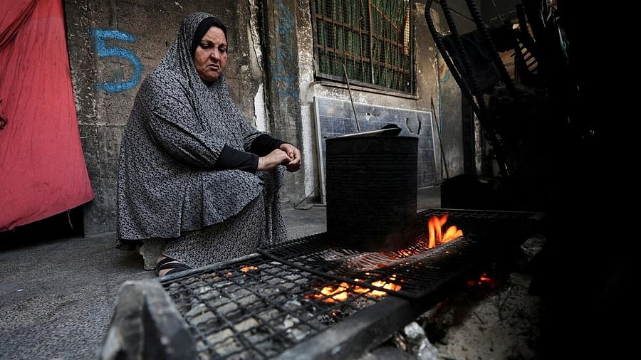 <div class="paragraphs"><p>A woman cooks as she shelters in an UNRWA-affiliated school in Jabalia refugee camp, in the northern Gaza Strip. </p></div>