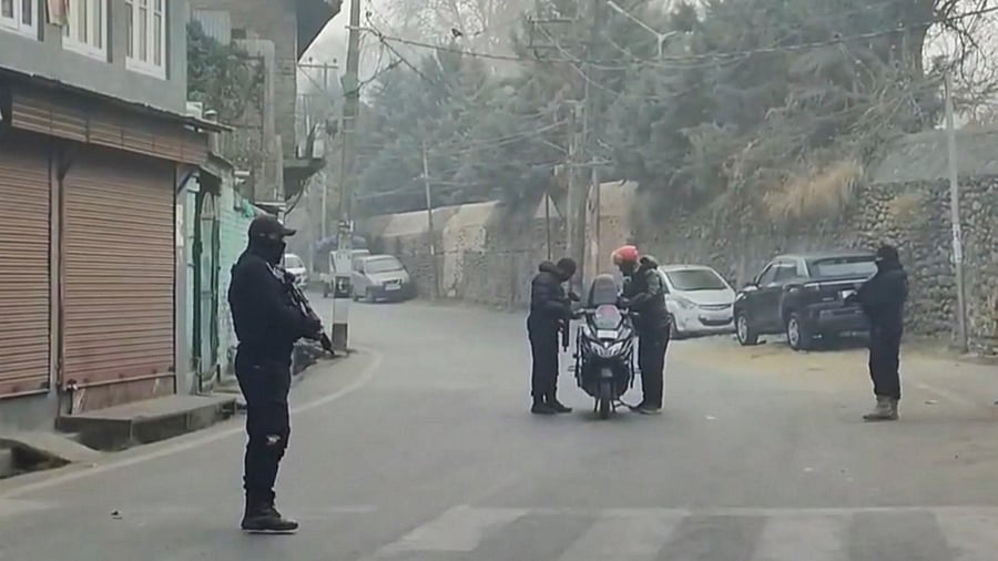 <div class="paragraphs"><p>Security personnel check a vehicle on a road.</p></div>