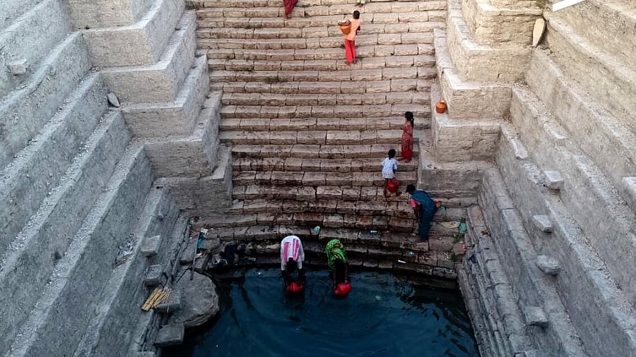 Women and children struggle to fetch drinking water from an ancient open well in Rajola village of Chittapur taluk in Kalaburagi district where groundwater level hasdepleted considerably.