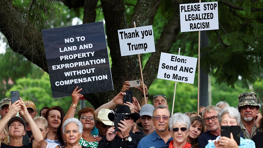 <div class="paragraphs"><p>Demonstrators hold placards in support of US President Donald Trump's stance against what he calls racist laws, land expropriation, and farm attacks, outside the American Embassy in Pretoria, South Africa, February 15, 2025. </p></div>