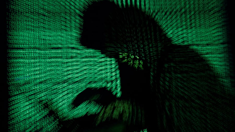 <div class="paragraphs"><p> A hooded man holds a laptop computer as cyber code is projected on him in this illustration picture</p></div>