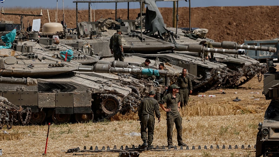 <div class="paragraphs"><p>Israeli soldiers work next to a tank near the Israel-Gaza border.</p></div>