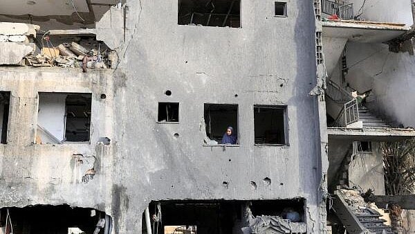 <div class="paragraphs"><p>A Palestinian looks out of a building, near the site of an Israeli strike on a house, in Khan Younis, in the southern Gaza Strip</p></div>