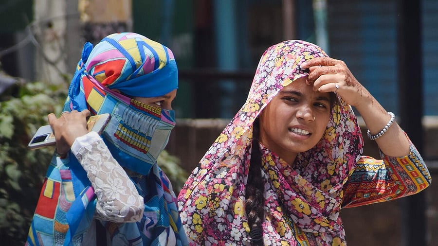 <div class="paragraphs"><p>Commuters use scarves to shield themselves from the heat on a hot summer day.</p></div>