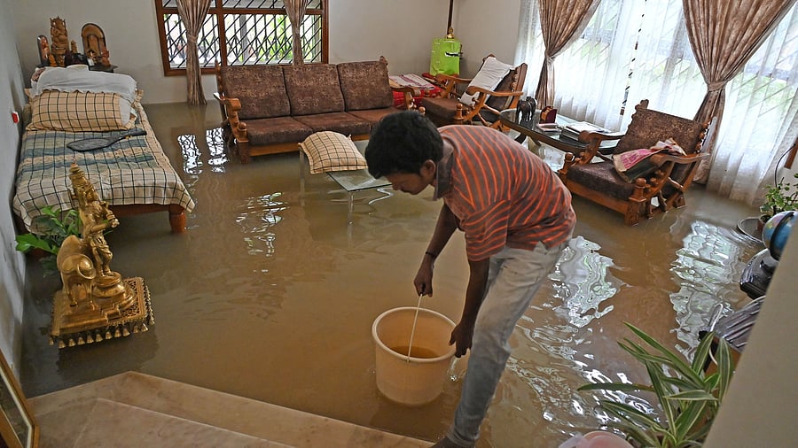 <div class="paragraphs"><p>People clear rainwater that entered homes in BTM Layout.&nbsp;</p></div>