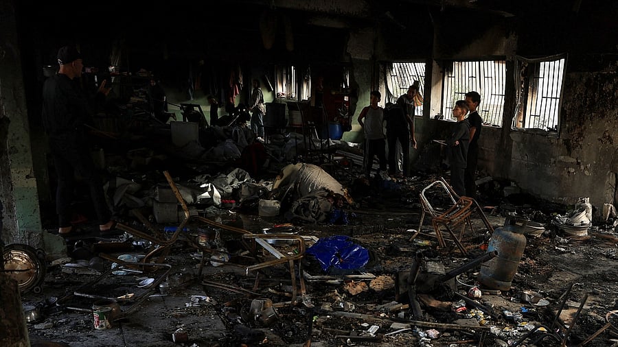 <div class="paragraphs"><p>Palestinians inspect the damage at a school sheltering displaced people, following an Israeli strike.</p></div>