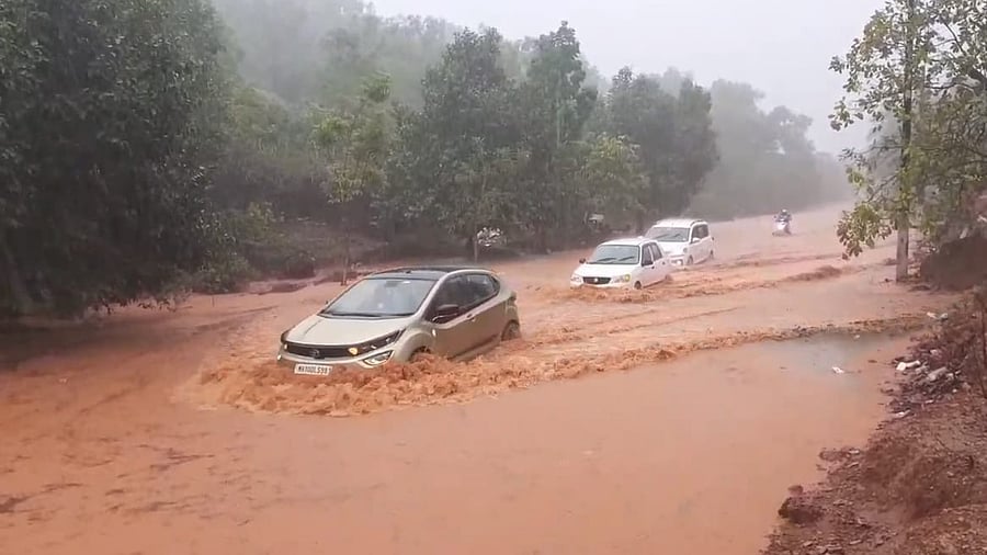 <div class="paragraphs"><p>Motor vehicles navigate on a flooded stretch of State Highway 48 near Santheguli in Kumta taluk of Uttara Kannada district on Tuesday.</p></div>
