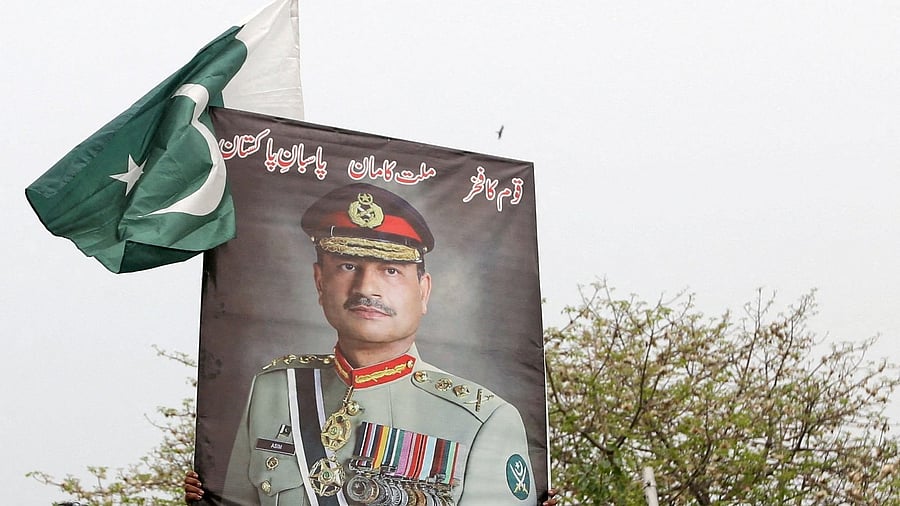 <div class="paragraphs"><p>People carry posters showing the pictures of Chief of Army Staff of Pakistan Asim Munir.</p></div>