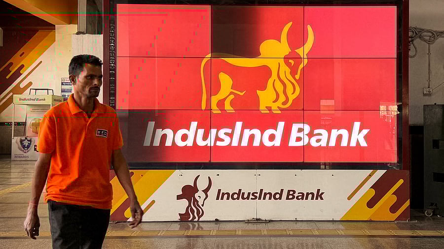<div class="paragraphs"><p>A man walks past a screen displaying the logo of IndusInd Bank at a metro station in New Delhi.</p></div>
