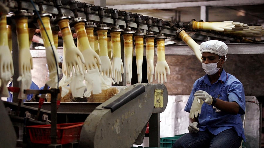 <div class="paragraphs"><p>A worker monitors a production line at a glove factory. </p></div>
