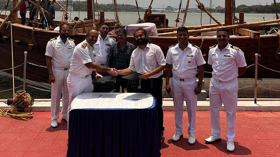 <div class="paragraphs"><p>Navy officials with the ship behind them.</p></div>