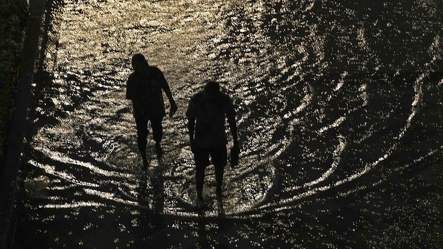 <div class="paragraphs"><p> People wade through a waterlogged road following a storm, in Greater Noida,</p></div>
