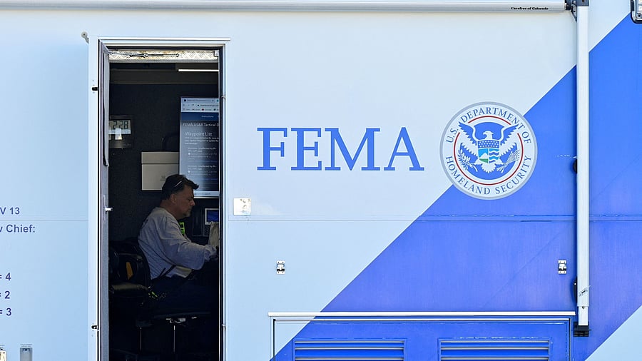 <div class="paragraphs"><p>A person sits at a desk inside of a mobile FEMA command center </p></div>