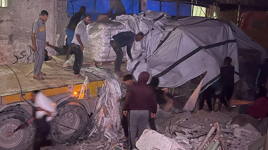 <div class="paragraphs"><p>Palestinian workers unload sacks of flour from an aid truck at a bakery, in Khan Younis, southern Gaza Strip, May 21, 2025.</p></div>