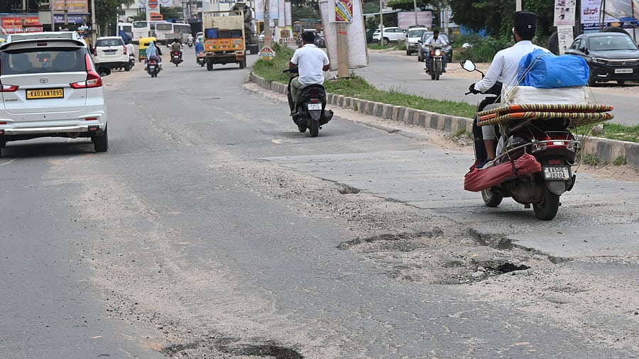 Six-inch deep potholes turn Hennur-Bagalur Road into an obstacle course for airport-bound travellers.