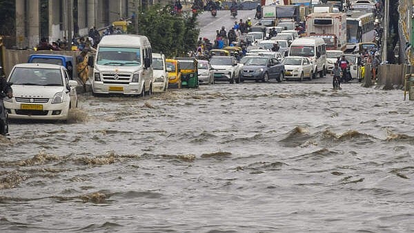 <div class="paragraphs"><p>Vehicles move through a waterlogged road after heavy rains, in Bengaluru.</p></div>