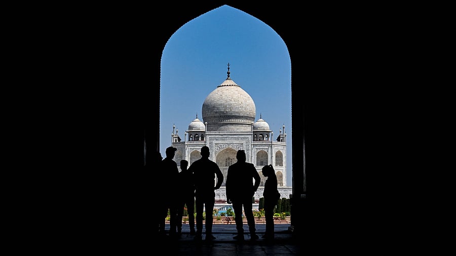 <div class="paragraphs"><p>People look at the Taj Mahal from the entrance of the grounds.</p></div>