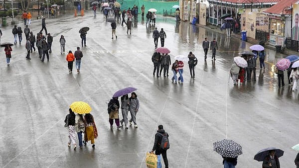 <div class="paragraphs"><p>Commuters on a road amid rain, in Shimla.</p></div>