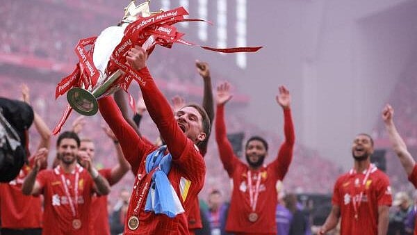 <div class="paragraphs"><p>Liverpool's Alexis Mac Allister celebrates with the trophy after winning the Premier League.</p></div>