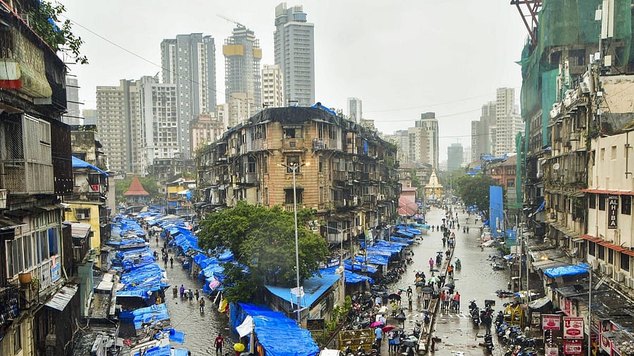 <div class="paragraphs"><p>People wade through waterlogged roads amid rains at Byculla, in Mumbai, Monday, May 26, 2025.</p></div>