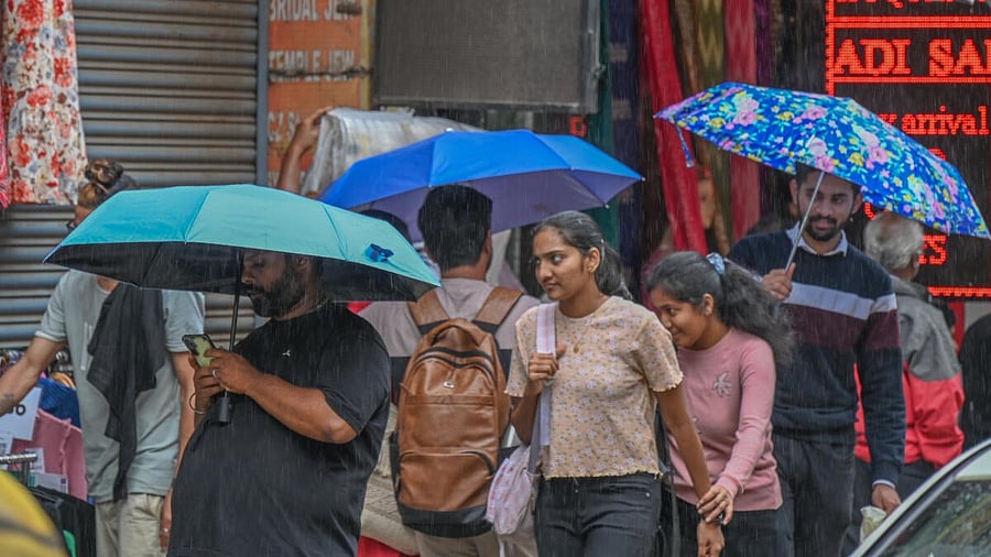 <div class="paragraphs"><p>People walking around with umberallas during rain in Bengaluru.</p></div>