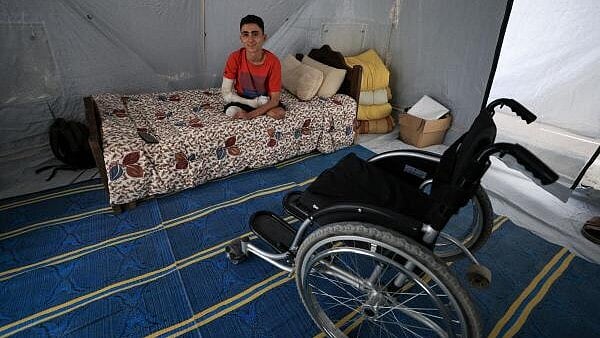 <div class="paragraphs"><p>Ahmad Al-Ghalban, a 16-year-old Palestinian gymnast, who lost both his legs in an Israeli airstrike on Beit Lahiya, sits on his bed inside the tent where he took shelter after being displaced, in Gaza City.</p></div>