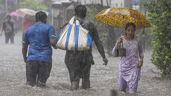 <div class="paragraphs"><p>People make their way through a waterlogged road.</p></div>