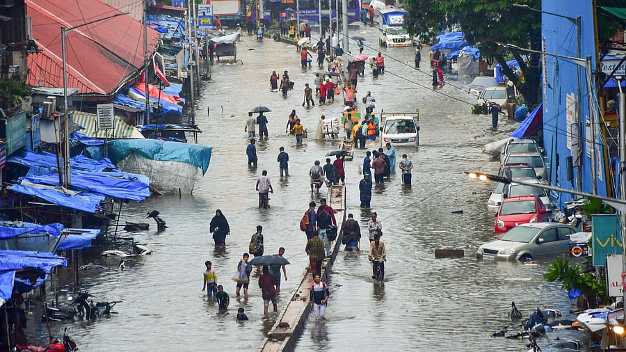 <div class="paragraphs"><p>People wade through a waterlogged road amid rains at Byculla, in Mumbai, Monday, May 26, 2025.</p></div>