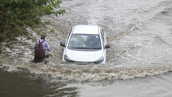 <div class="paragraphs"><p>A car moves on the waterlogged service road along the Delhi-Gurugram Expressway after heavy rainfall, in Gurugram.</p></div>