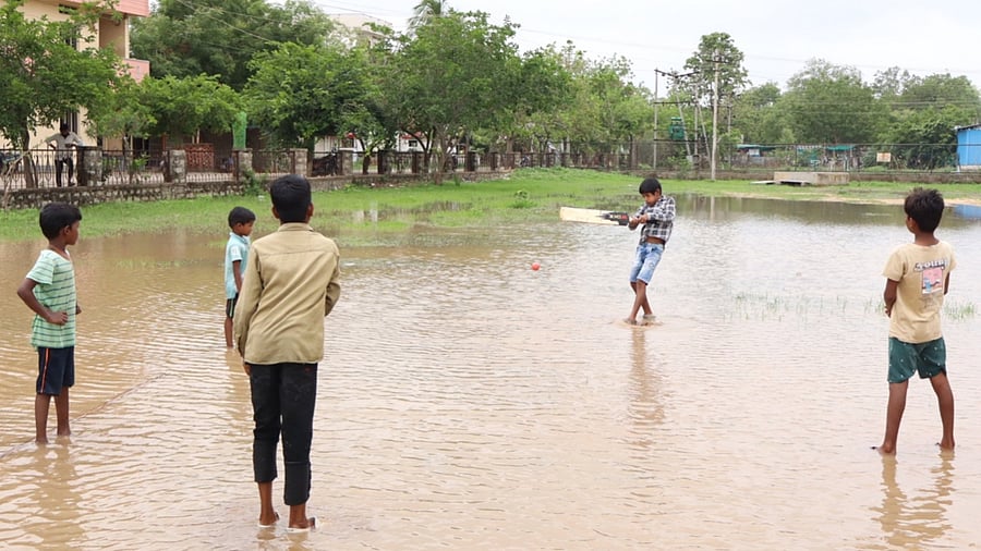 <div class="paragraphs"><p>Rain and a flooded playground can’t dampen the spirit as children play cricket at Nazarath Colony in Yadgir on Thursday. </p></div>