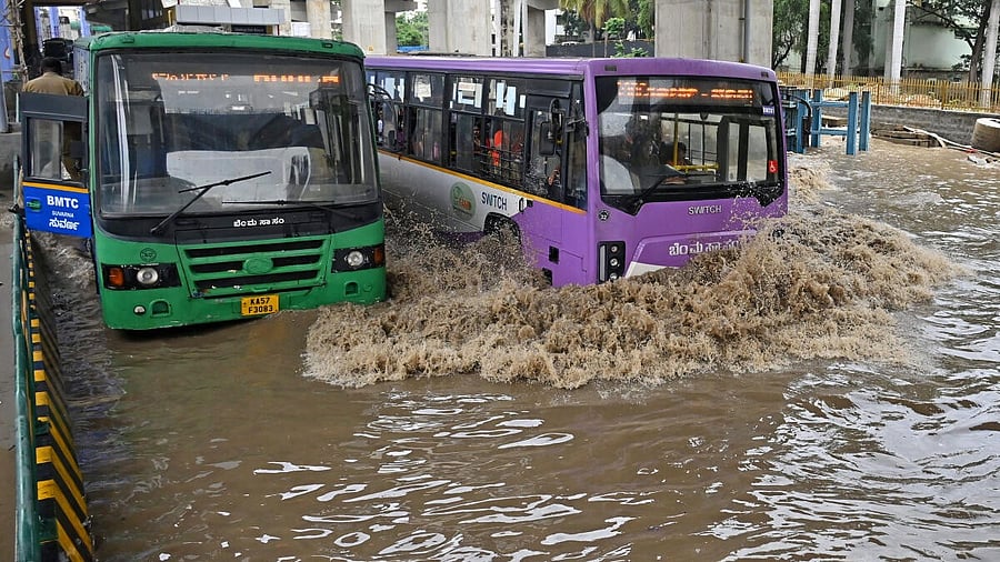 <div class="paragraphs"><p>Buses and heavy vehicles wave through flooded streets at Silk Board junction after heavy rains in Bengaluru on Monday, May 19, 2025. </p></div>