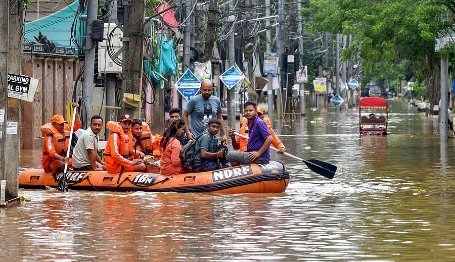 <div class="paragraphs"><p>National Disaster Response Force (NDRF) personnel and others move through a waterlogged road aboard a rescue boat to distribute relief material to affected people at an area inundated with rainwater after heavy rainfall, in Guwahati, Assam, Saturday, May 31, 2025.</p></div>