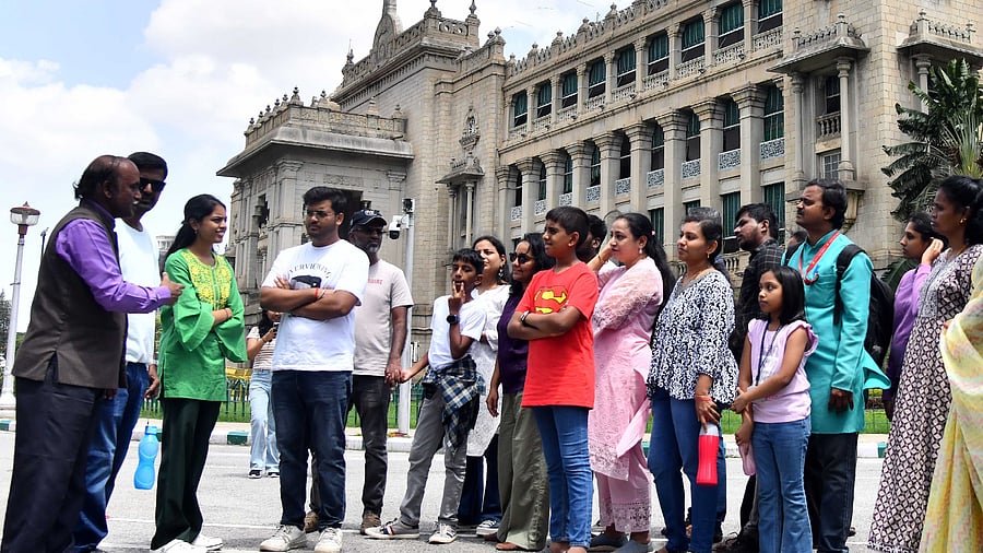 A guide takes a group of people on a tour of Vidhana Soudha in Bengaluru on Sunday.