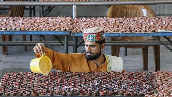<div class="paragraphs"><p>A devotee pours oil into earthen lamps on the eve of the 'Kheer Bhawani Mela', in Jammu, Sunday, June 1, 2025.</p></div>