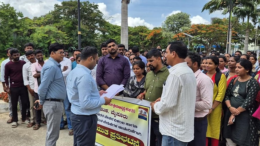 <div class="paragraphs"><p>President of Mysuru district unit of MNREGA Employees Association Manjunath submits a memorandum to Zilla Panchayat CEO S Yukesh Kumar, seeking payment of pending salaries. Deputy Secretary (Development) Krishna Raju is seen.</p></div>