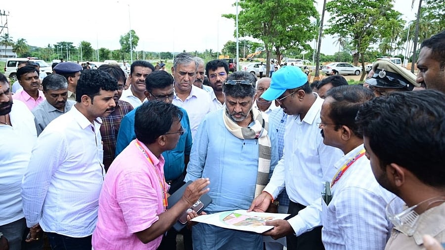 <div class="paragraphs"><p>Deputy Chief Minister DK Shivakumar and officials at the Nadaprabhu Kempegowda Layout on Tuesday.&nbsp;</p></div>