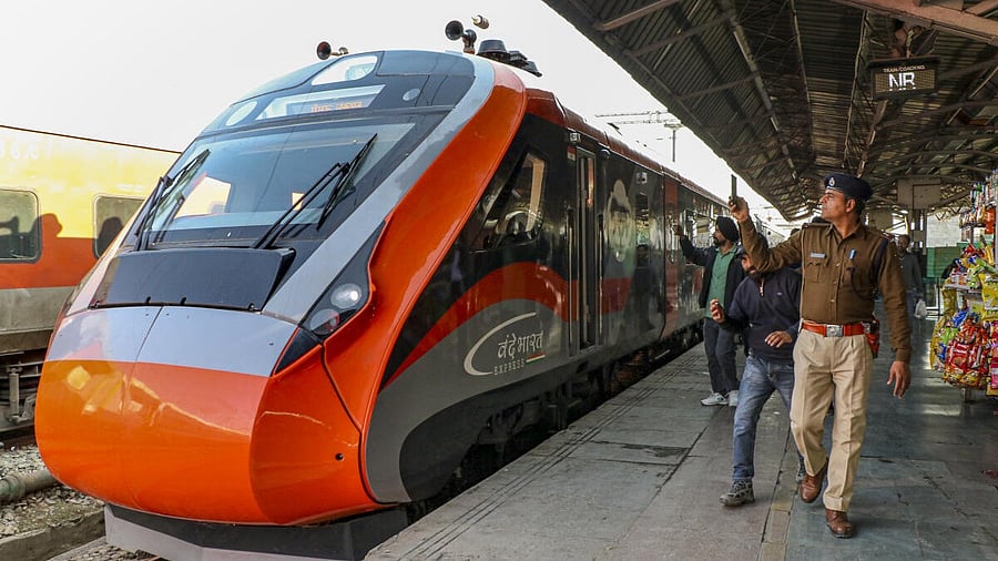 <div class="paragraphs"><p>People click photographs of a Vande Bharat Express train, that will run on the Katra-Srinagar route.</p></div>