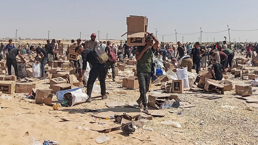 <div class="paragraphs"><p>Palestinians gather to collect what remains of relief supplies from the distribution center of the US-backed Gaza Humanitarian Foundation, in Rafah, in the southern Gaza Strip.</p></div>