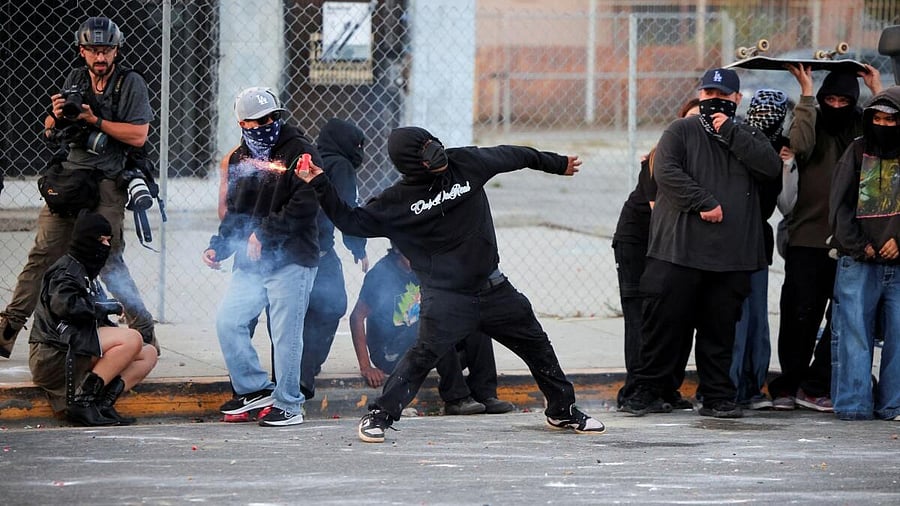 <div class="paragraphs"><p>A protester throws a firework during a standoff between police and protesters following multiple detentions by Immigration and Customs Enforcement (ICE), in the Los Angeles County city of Paramount, California</p></div>