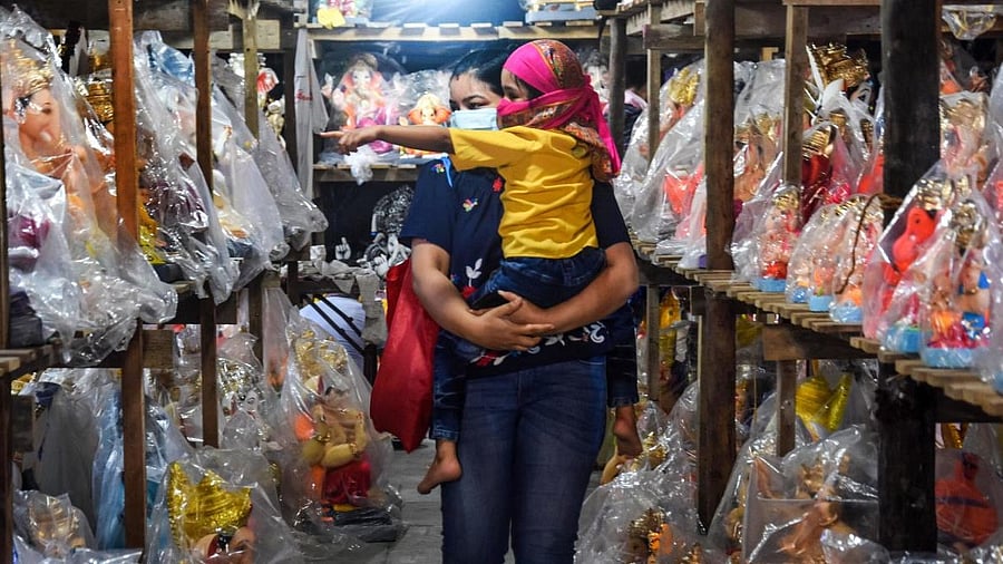 <div class="paragraphs"><p>A woman carrying her child looks to purchase Lord Ganesha idol at a Ganpati workshop, during Unlock 2.0, at Andheri in Mumbai, Saturday, July 18, 2020. (Image for representation)</p></div>